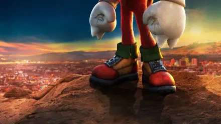 Knuckles (2024) 2K Quad HD PC desktop wallpaper: close-up of Knuckles' boots and fists on a cliff overlooking a sunlit cityscape.