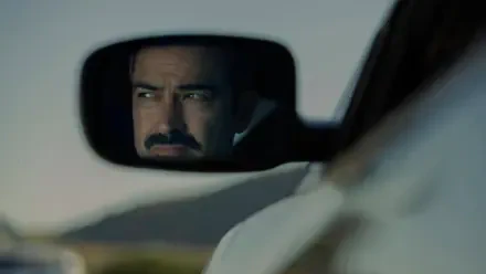 4K Ultra HD PC desktop wallpaper: mustachioed man’s intense face reflected in a car rearview mirror, confronting an unseen presence—tense, cinematic close-up.