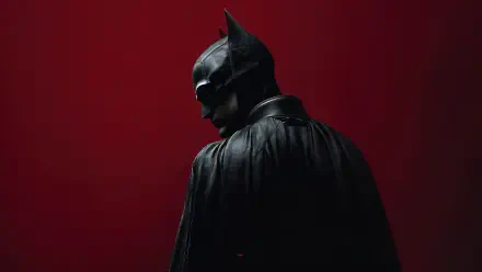 Moody digital art of Batman in cape and cowl against a deep red background — 4K Ultra HD superhero PC desktop wallpaper and background.