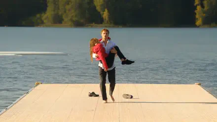4K Ultra HD PC desktop wallpaper: Crew Girl Netflix couple on a sunlit dock, a man carrying a woman across a calm lake.