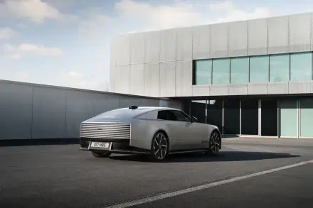 Jaguar Type 01 electric sedan parked outside a modern building, featured in a 5K Ultra HD PC desktop wallpaper.