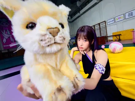 IVE’s An Yujin poses beside a large plush cat in a vivid Looks Can Kill scene, 4K Ultra HD desktop wallpaper.