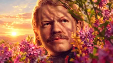 Plutarch Heavensbee from The Hunger Games in a flower-framed sunset portrait, 4K Ultra HD PC desktop wallpaper and background.