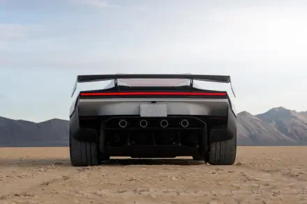Rear view of a futuristic Tesla Roadster on a desert plain, featured in a 2K Quad HD desktop wallpaper.
