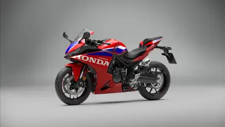 Red Honda CBR500R Four sportbike on a gray studio background, featured in a 5K Ultra HD desktop wallpaper.