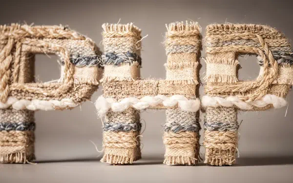 4K Ultra HD PC desktop wallpaper showing the letters PHP crafted from frayed woven rope and fabric textures against a neutral background.