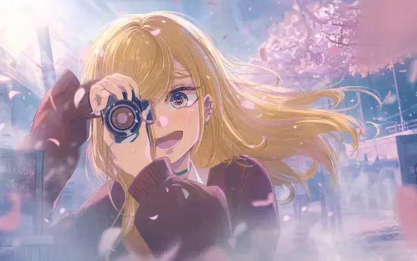 My Dress-Up Darling 4K Ultra HD PC desktop wallpaper/background: cheerful blonde girl holding a camera beneath falling cherry blossoms, wind-tossed hair and glowing pastel light.