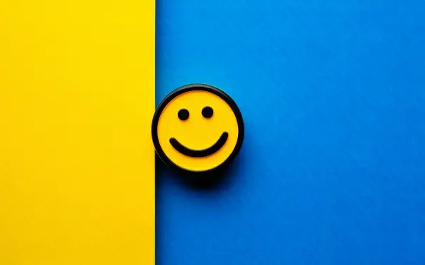 Smiley face badge centered on a vertical split yellow and blue field — 5K Ultra HD PC desktop wallpaper and background.