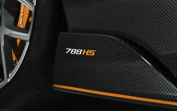 Close-up of McLaren 788HS carbon-fiber side sill and wheel with orange accent stripe — 8K Ultra HD PC desktop wallpaper