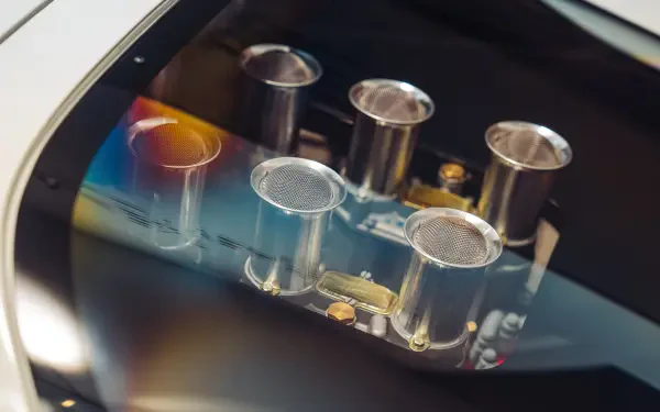 Close-up of polished intake trumpets on a McLaren G6GT engine, vivid reflections and fine detail — 8K Ultra HD PC desktop wallpaper background showcasing McLaren vehicle craftsmanship.