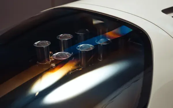 Close-up of McLaren G6GT engine intakes visible through glass; 8K Ultra HD vehicle PC desktop wallpaper and background.