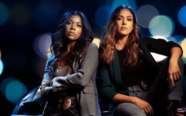 Two female detectives in dark jackets lean on a car with blurred city lights — L.A.'S Finest 4K Ultra HD PC desktop wallpaper and background.