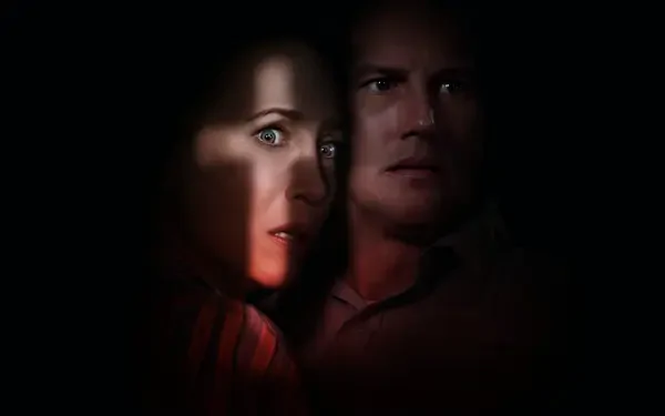 Dark 4K Ultra HD PC desktop wallpaper for The Conjuring: The Devil Made Me Do It showing two tense, shadowed faces lit by a narrow beam of light against a black background.