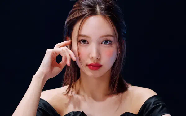 5K Ultra HD desktop wallpaper: close-up portrait of a young woman with K-pop-inspired styling—shoulder-length hair, red lips, off-shoulder black top, hand near face on dark background.