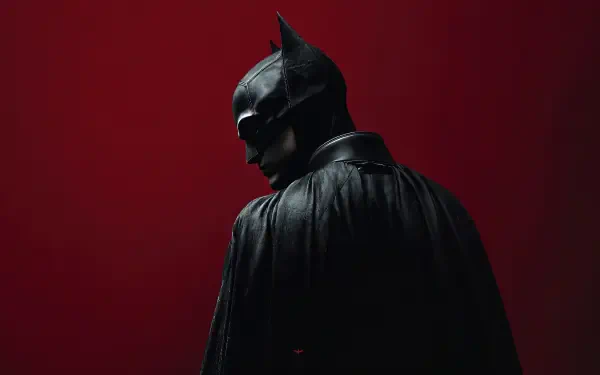 Moody digital art of Batman in cape and cowl against a deep red background — 4K Ultra HD superhero PC desktop wallpaper and background.