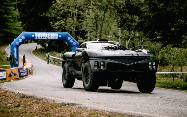 Genesis X Skorpio supercar rally racer on a forest road passing a finish arch, black sports/race car — 4K Ultra HD PC desktop wallpaper background.