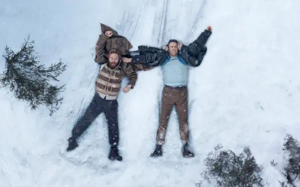 4K Ultra HD PC desktop wallpaper: aerial view of two men lying in snow with arms outstretched, forming a Mayday signal beside scattered pine branches.