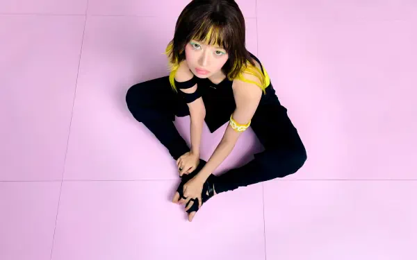 IVE Rei model in a black and yellow outfit against a pink backdrop, featured in Looks Can Kill 4K Ultra HD desktop wallpaper.