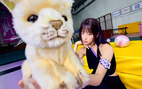 IVE’s An Yujin poses beside a large plush cat in a vivid Looks Can Kill scene, 4K Ultra HD desktop wallpaper.
