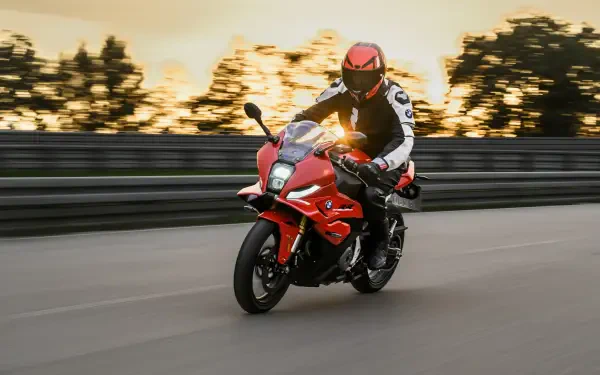 BMW Motorrad F 450 RR sport motorcycle ridden on a road at sunset, featured in a 5K Ultra HD desktop wallpaper.