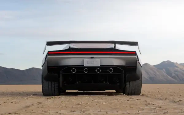 Rear view of a futuristic Tesla Roadster on a desert plain, featured in a 2K Quad HD desktop wallpaper.