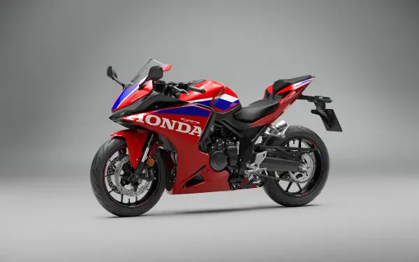 Red Honda CBR500R Four sportbike on a gray studio background, featured in a 5K Ultra HD desktop wallpaper.