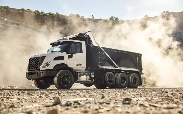 Volvo VNX dump truck hauling across a dusty construction site, captured in crisp 8K Ultra HD PC desktop wallpaper.