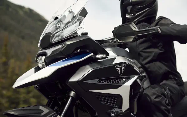 Triumph Tiger 1200 motorcycle with a helmeted motorcyclist, featured in an 8K Ultra HD desktop wallpaper.