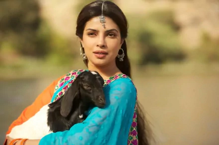 High-definition wallpaper featuring Priyanka Chopra holding a goat in a vibrant traditional outfit, showcasing a serene outdoor setting.