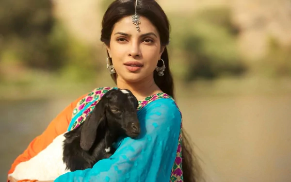 High-definition wallpaper featuring Priyanka Chopra holding a goat in a vibrant traditional outfit, showcasing a serene outdoor setting.