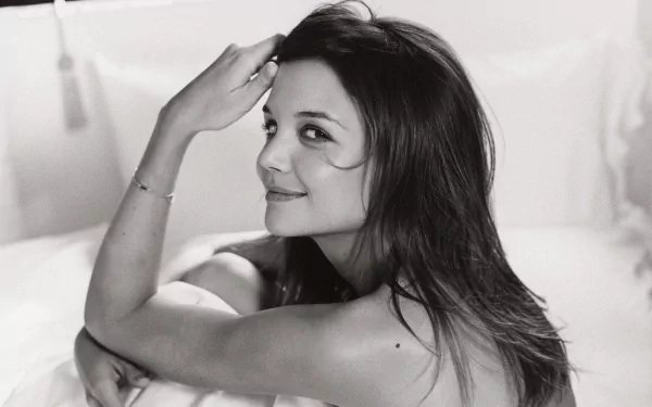 Black and white HD desktop wallpaper featuring a close-up portrait of celebrity Katie Holmes smiling softly while resting her head on her arms.