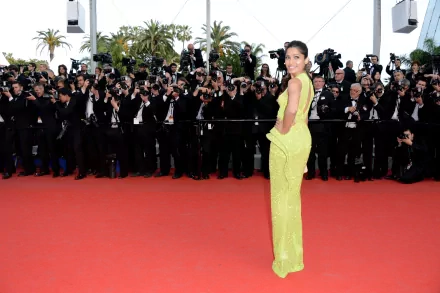 Freida Pinto dazzles on the red carpet, surrounded by photographers, showcasing her elegance in a bright yellow gown. A striking 4K Ultra HD background for any desktop.