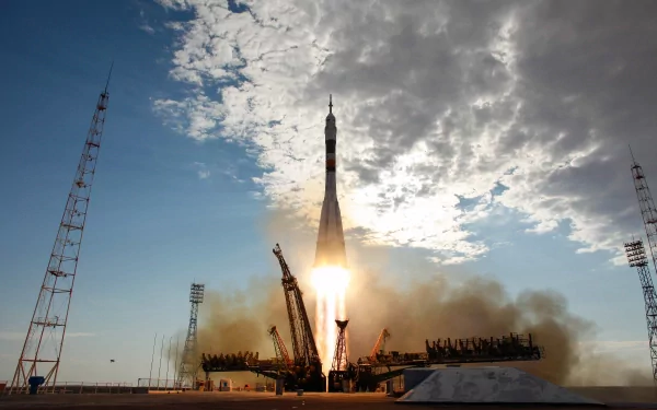 HD desktop wallpaper featuring a man-made rocket launching amidst clouds of smoke, with a clear blue sky and scattered clouds in the background.