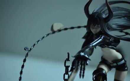 HD PC desktop wallpaper of Black Gold Saw (Black Rock Shooter): armored anime figure with horned headpiece and chained saw-whip in a dynamic pose against a blurred background.