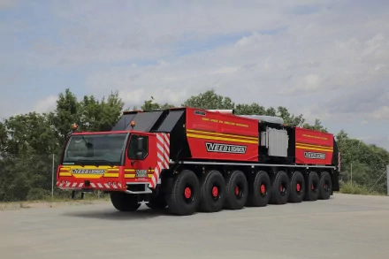 4K Ultra HD desktop wallpaper featuring a large Liebherr heavy-duty vehicle with multiple wheels, set against a cloudy sky and green trees background.