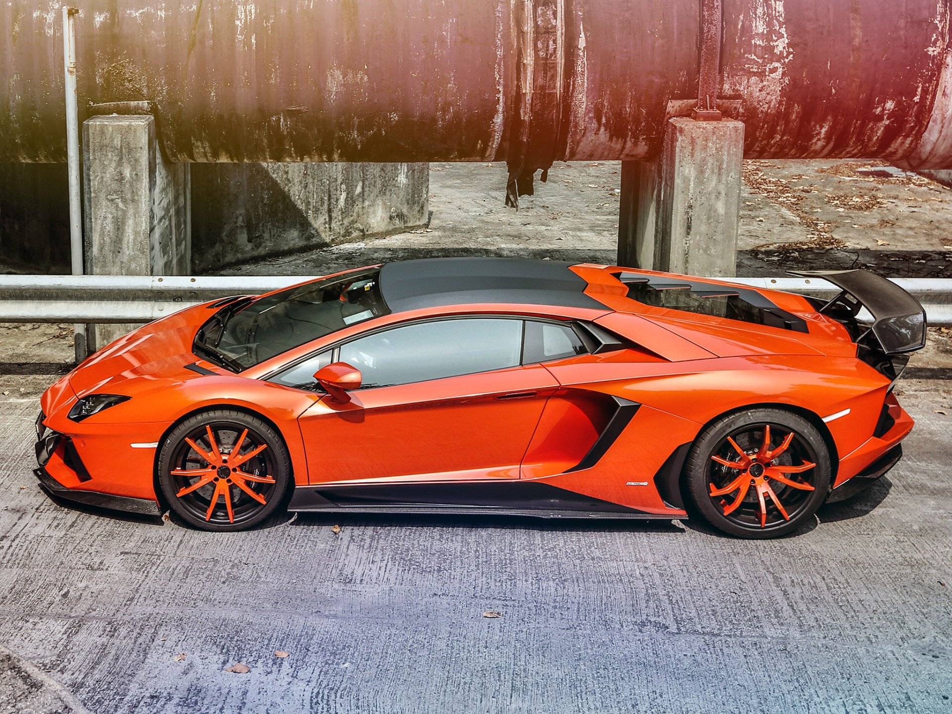 Orange Lamborghini Aventador LP 700-4 side view on concrete, HD PC desktop wallpaper background with black aero accents and glossy reflections.