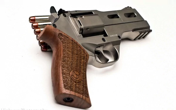 HD PC desktop wallpaper featuring a detailed close-up of a man-made Chiappa Rhino revolver with wooden grip and visible bullets against a white background.