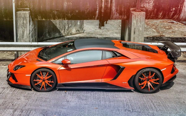 Orange Lamborghini Aventador LP 700-4 side view on concrete, HD PC desktop wallpaper background with black aero accents and glossy reflections.
