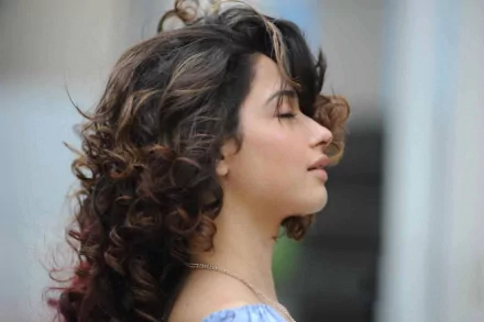 HD PC desktop wallpaper featuring a side profile of celebrity Tamannaah Bhatia with curly hair and a serene expression.