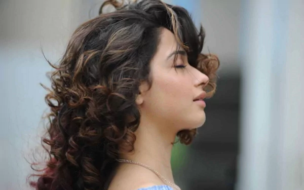 HD PC desktop wallpaper featuring a side profile of celebrity Tamannaah Bhatia with curly hair and a serene expression.