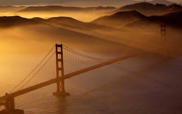 A stunning HD desktop wallpaper featuring the Golden Gate Bridge shrouded in golden mist with rolling hills in the background.