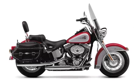 HD desktop wallpaper featuring a side view of a Harley-Davidson Heritage Softail Classic motorcycle. The bike stands out with its vintage design elements and studded leather saddlebag.