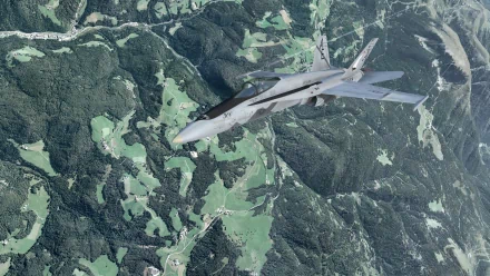 2K Quad HD PC desktop wallpaper from the video game Microsoft Flight Simulator showing a fighter jet soaring above forested mountains and patchwork green valleys.