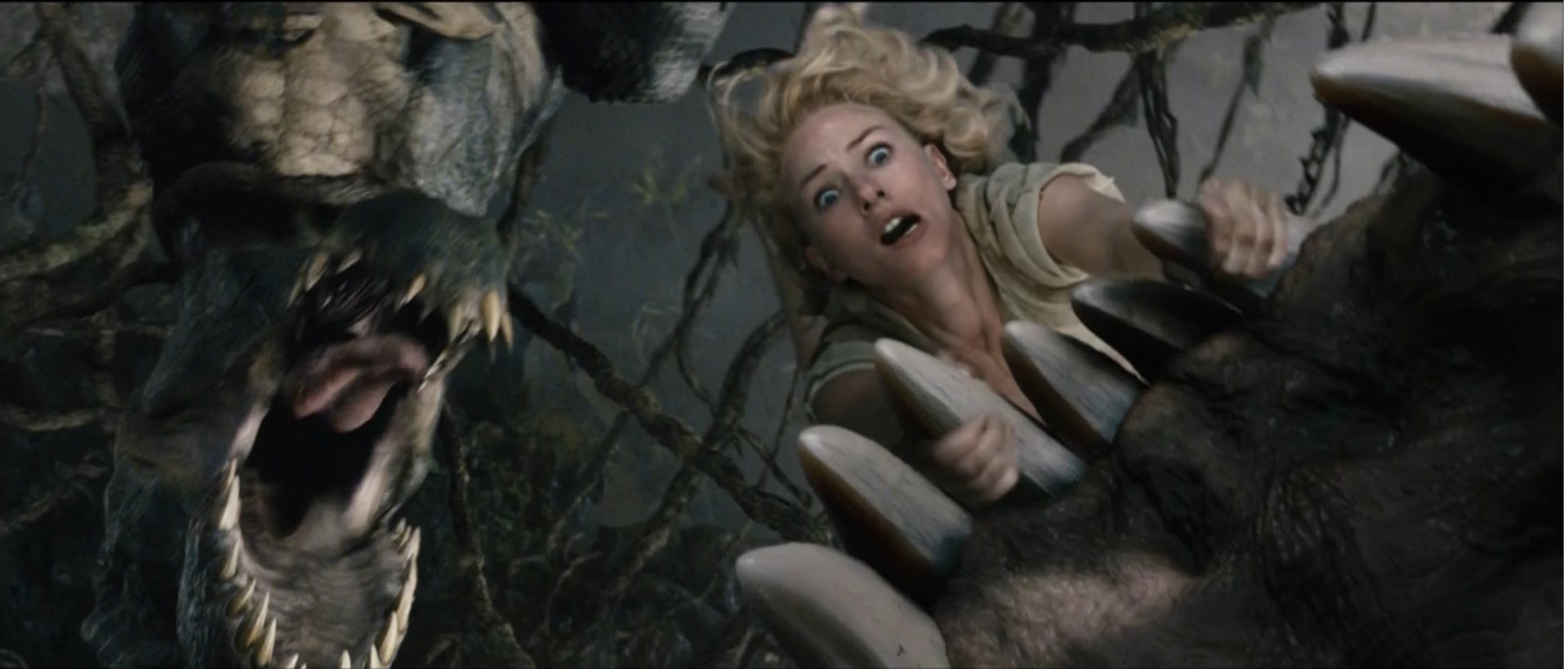 HD PC desktop wallpaper from the movie King Kong (2005) showing a woman in distress gripping King Kong's giant claw while a snarling beast approaches.
