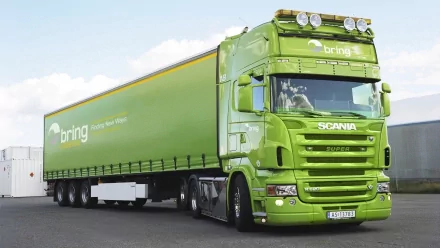 A striking green Scania truck with a refrigerated trailer, showcasing a sleek design. This HD image serves as a vibrant desktop wallpaper and background.