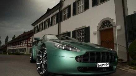 Green Aston Martin Vantage vehicle parked before a European manor under a moody sky — HD PC desktop wallpaper and background, sleek sports-car profile.