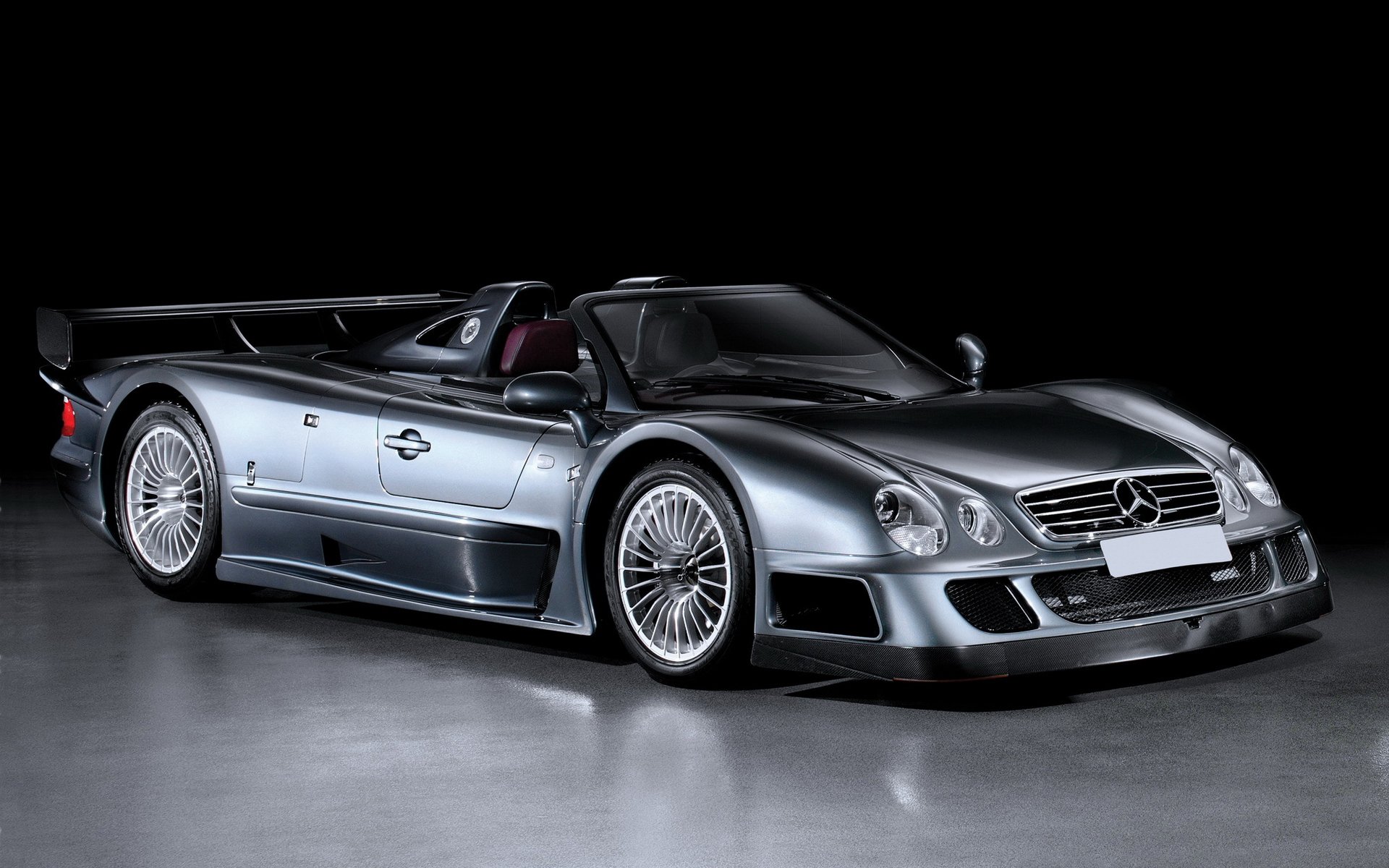 HD desktop wallpaper featuring a sleek, silver Mercedes convertible sports car with a polished finish and detailed design against a dark background.