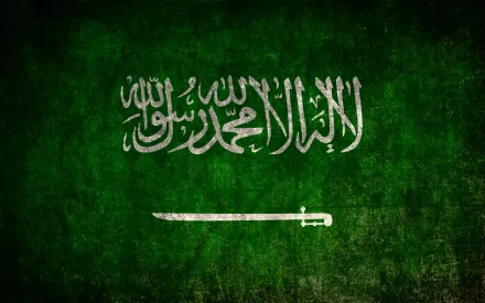 HD PC desktop wallpaper featuring the green Flag of Saudi Arabia with its white Arabic inscription and sword on a textured background.