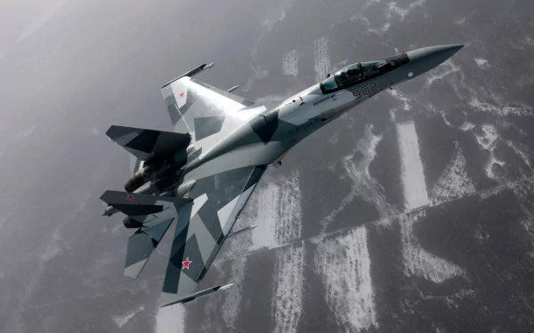 A high-definition wallpaper featuring a Sukhoi Su-27 aircraft in flight, showcasing its distinctive design and military capabilities against a backdrop of clouded terrain.