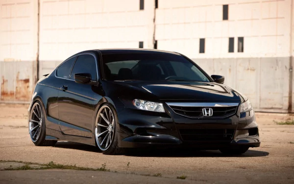 HD PC desktop wallpaper/background: sleek black Honda vehicle coupe with low stance and aftermarket wheels parked before a weathered industrial wall.